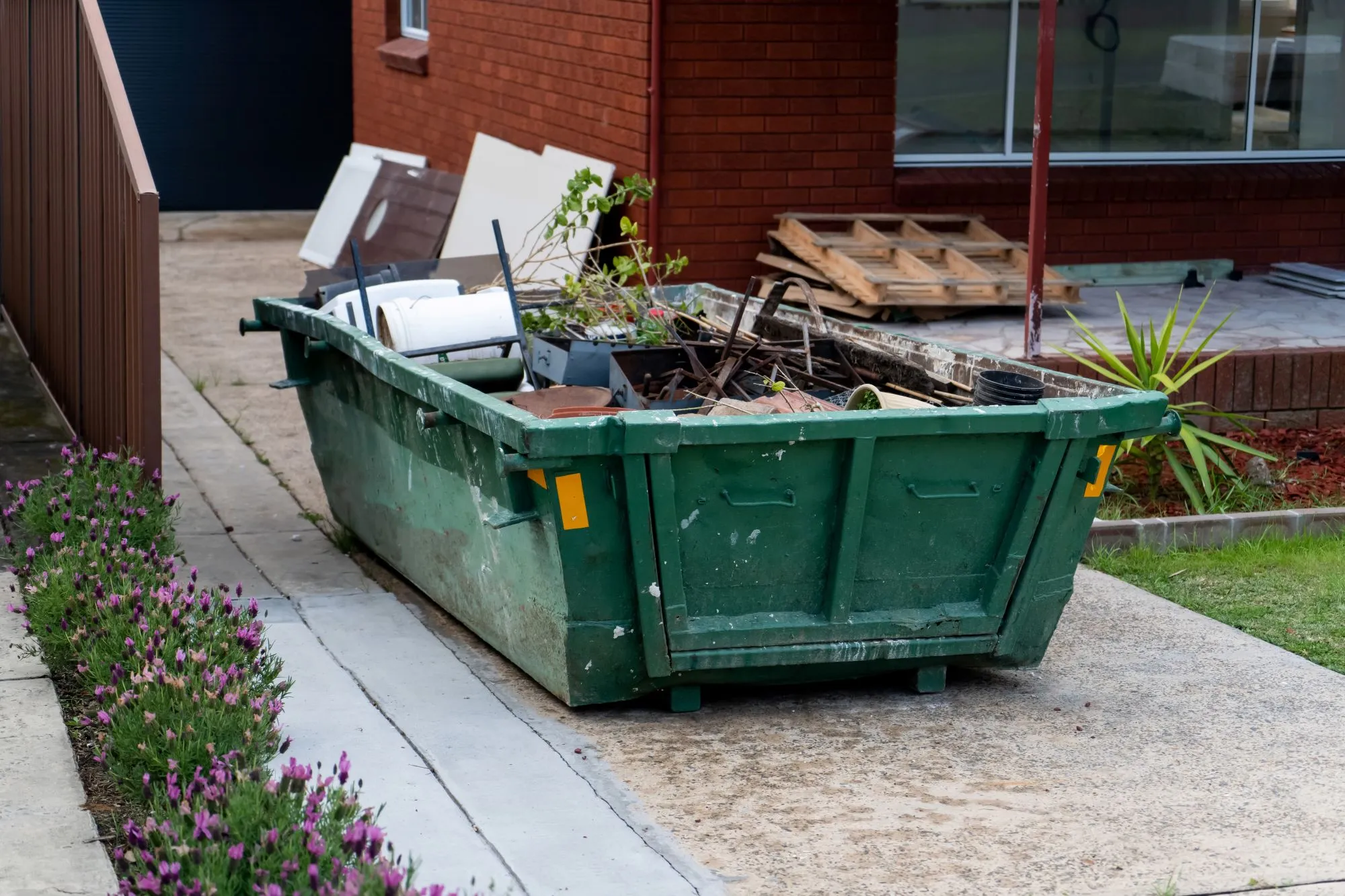 Junk removal truck beside a dumpster during a property cleanup project in Edmonton