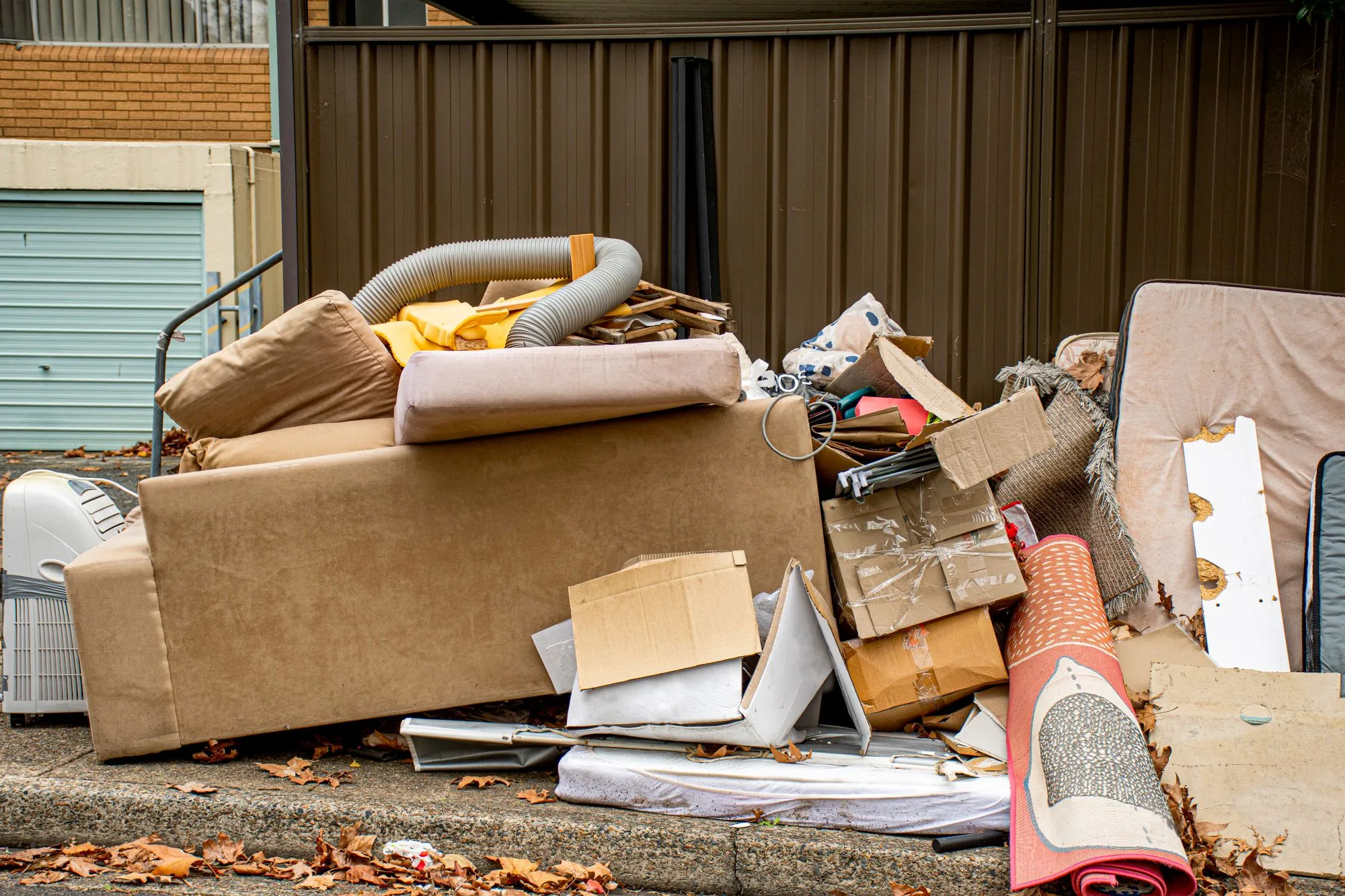 Junk removal crew carrying furniture through an Edmonton condo building hallway.