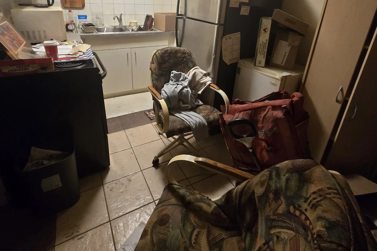 Apartment kitchen with chairs, boxes, a bar fridge and personal belongings still inside before a 2 Kings estate cleanout in Edmonton